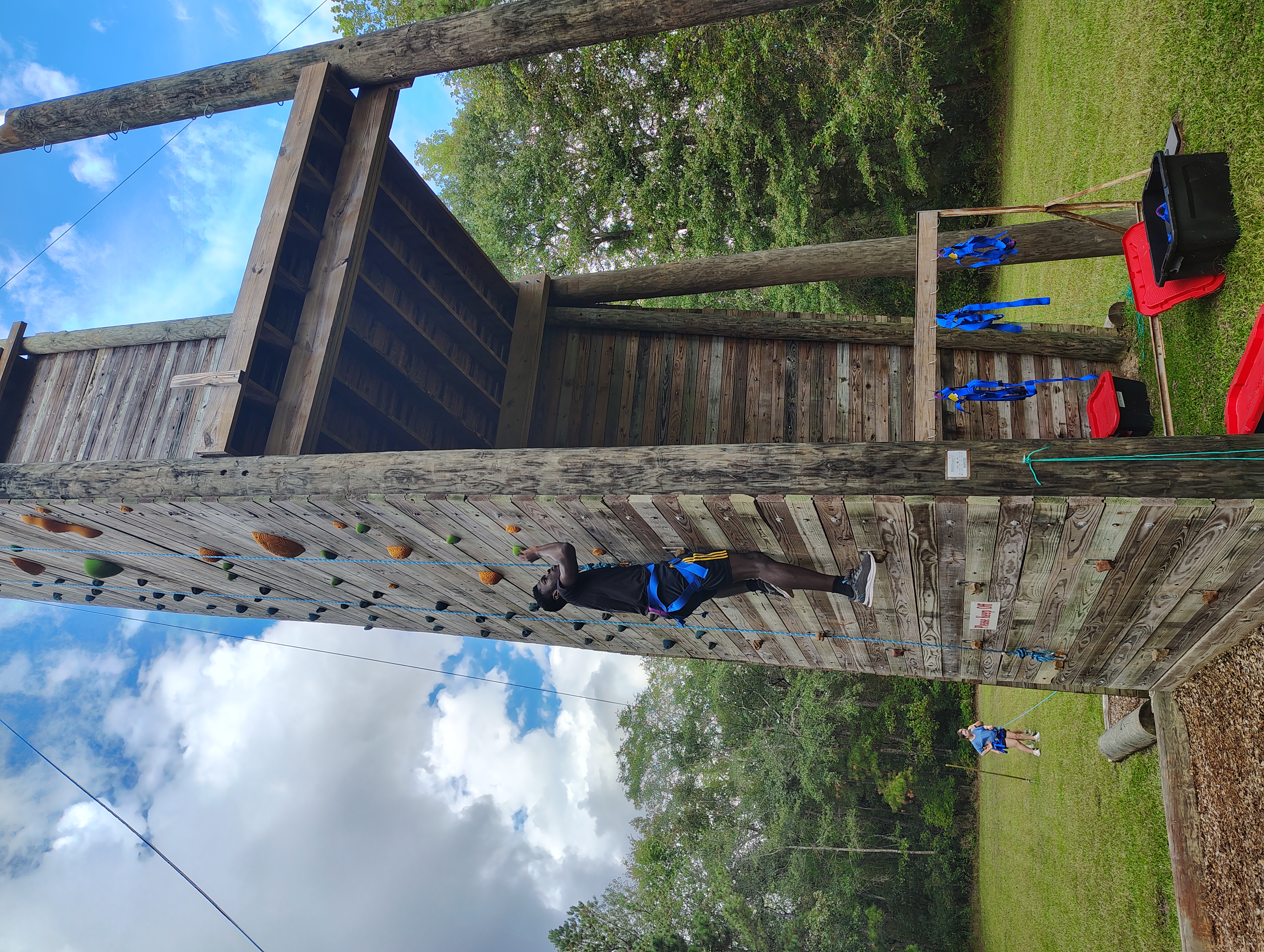 Student climbing the rock wall at Fall Retreat